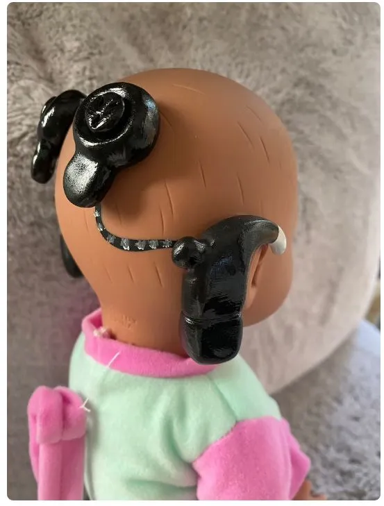 ethnic doll with cochlear implant
