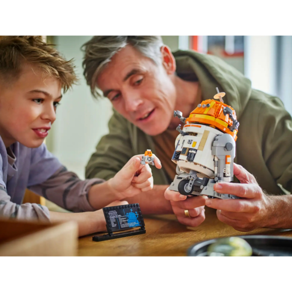 A father and son play with the LEGO Star Wars Chopper Astromech Droid playset