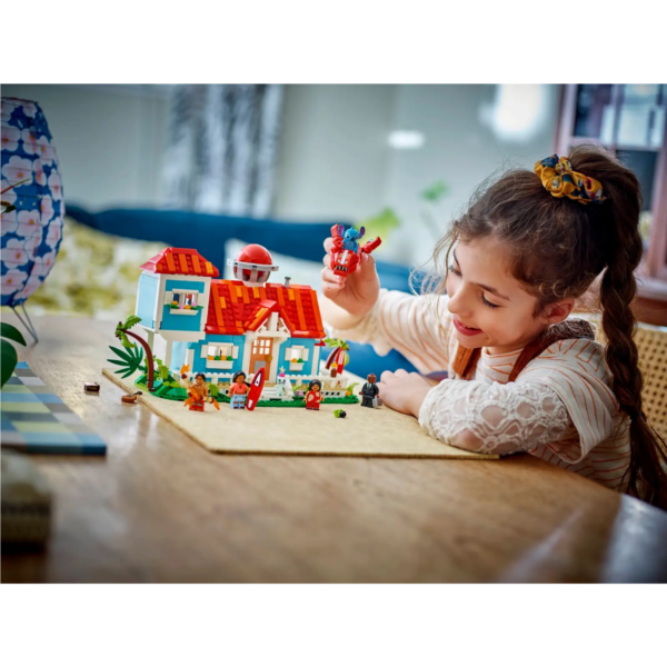 A young caucasian girl playing with LEGO Disney's Lilo and Stitch Beach House playset
